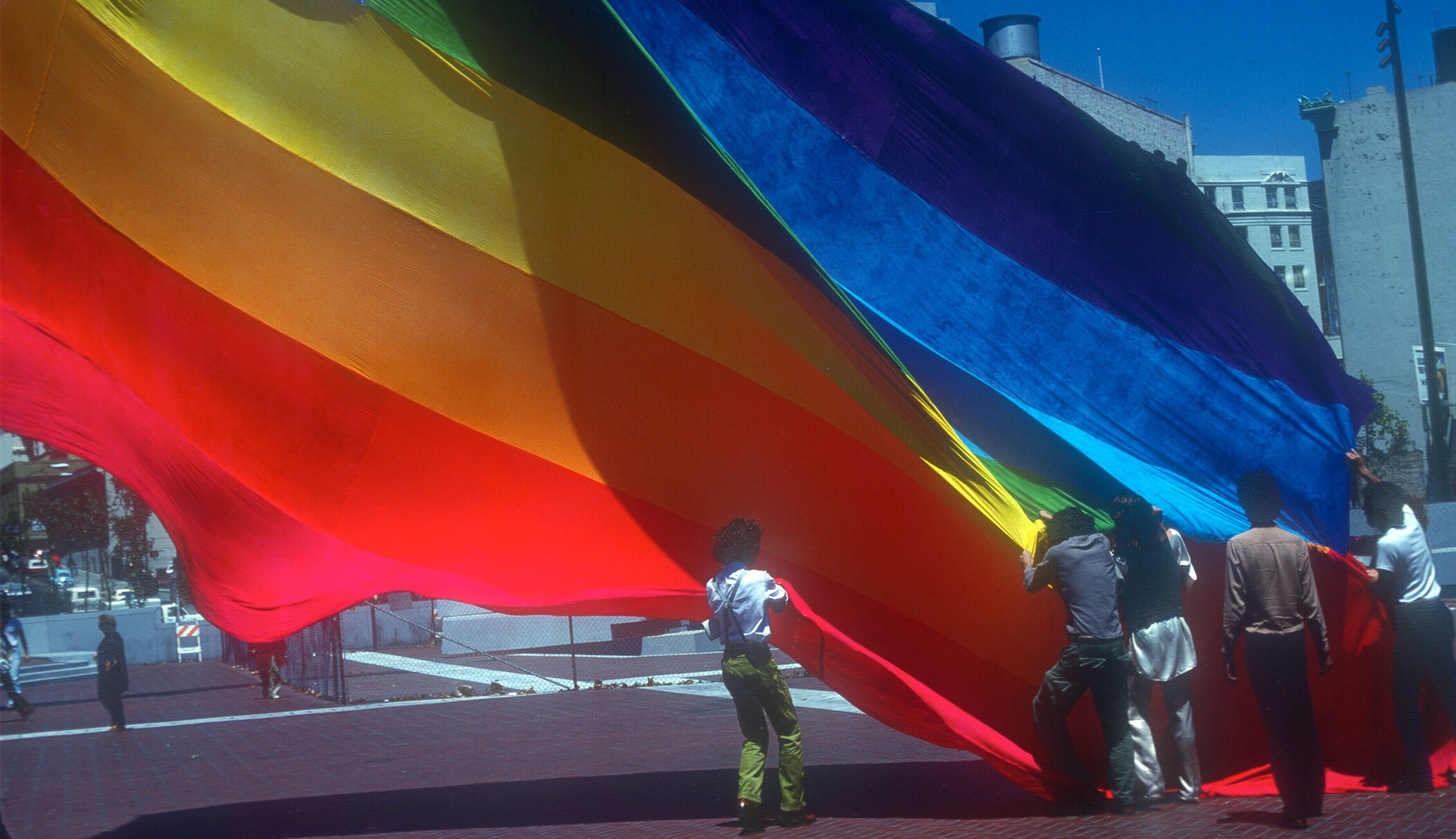 Gilbert Baker et des volontaires hissent le drapeau Pride d’origine sur la place des Nations unies de San Francisco en 1978