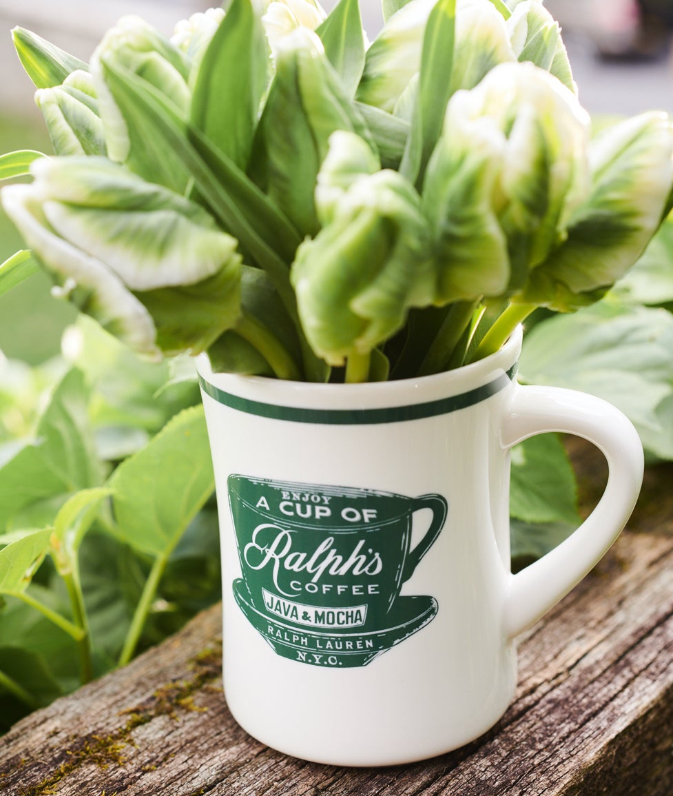 Une image joyeuse sur une table de cuisine : un mug &agrave; caf&eacute; rempli de boutons de fleurs non-caf&eacute;in&eacute;es cueillis dans le jardin