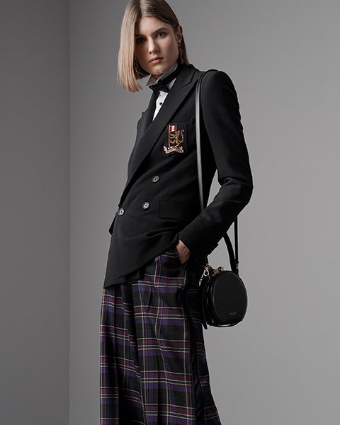 Woman in purple plaid dress with oversize purple faux-fur shawl